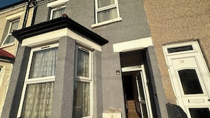 A corner of a building with a window, a door, and a mailbox. - Croydon Dream House on Lancing Road (Croydon)