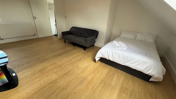 A room with a bed, a sofa, and a small table. - Croydon Dream House on Lancing Road (Croydon)