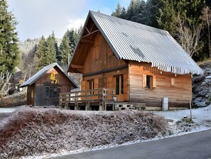 A wooden cabin with a metal roof, a wooden porch, and a small adjacent structure. - Mountain Chalet for 13 Guests (La Morte)