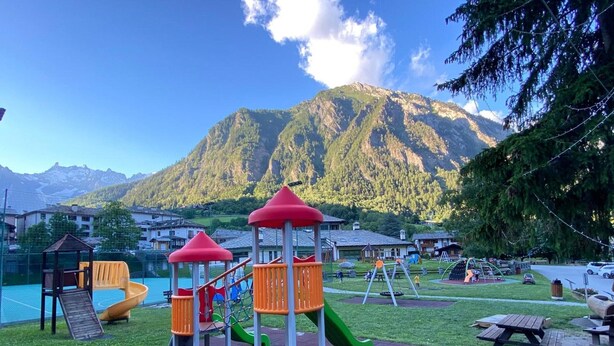 A playground with slides and climbing structures, surrounded by a mountain backdrop. - Apartment 'Maribel' with Shared Terrace and Wi-Fi (Pré-Saint-Didier)