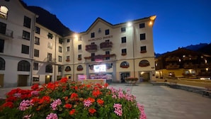A hotel with a central courtyard, flower beds, and a sign reading 'MUNICIPIO - AIRIE.' - Apartment 'Maribel' with Shared Terrace and Wi-Fi (Pré-Saint-Didier)