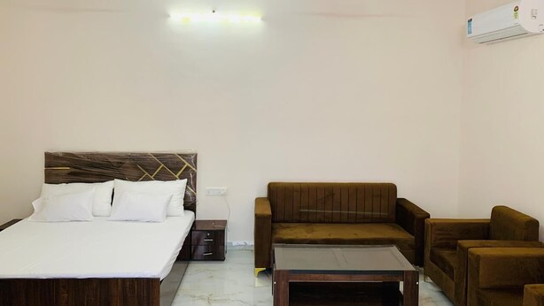 Ein Hotelzimmer mit Bett, Sofa, Couchtisch, Nachttisch und Klimaanlage.