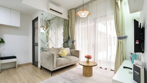 A modern living room with a sofa, a coffee table, and a TV mounted on the wall. - Cherry Houses - Masteri Thao Dien (Ho Chi Minh City)