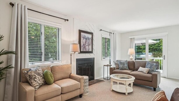 A living room with two sofas, a coffee table, and a fireplace.