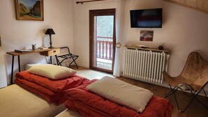 A bedroom with two beds, a desk, a chair, a radiator, and a TV. - 2nd floor, balcony, ski locker, 48m², Valloire (Valloire)