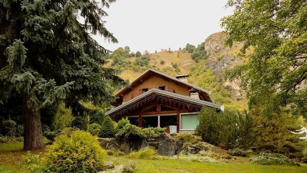 A wooden chalet with a sloped roof, surrounded by lush greenery and trees. - 2nd floor, balcony, ski locker, 48m², Valloire (Valloire)