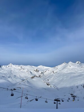 Ein mit Schnee bedeckter Berg mit Seilbahnen und blauem Himmel.