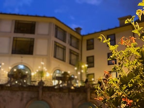 A building with multiple windows and a balcony with lights.