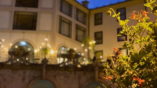 Un bâtiment doté de nombreuses fenêtres et d’un balcon illuminé.