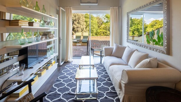 Una sala de estar moderna con sofá, mesa de centro y estanterías decoradas.