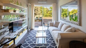 Uma sala de estar moderna com sofá, mesa de centro e prateleiras com objetos decorativos.