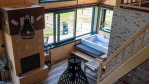 Ein Zimmer mit Kamin, großem Fenster, Badewanne und Treppe.