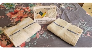 A bed with floral bedding, two folded towels, and a small box with toiletries. - A little jewel in the center of Algiers (El Biar)