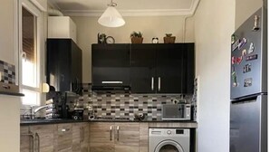 A compact kitchen with a washing machine, a refrigerator, and a microwave. - A little jewel in the center of Algiers (El Biar)