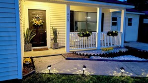 A house with a porch, a front door with a wreath, and a mailbox. - Modern Home w/ Theater, BBQ & Private Yard (Ladson)