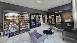 Um lobby moderno com áreas de estar e máquinas de venda automática identificadas como 'market4u'.
