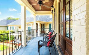 A covered porch with a ceiling fan, a bench with a red cushion, and a view of neighboring houses. - The Aimee, 4BR Luxe by Velvet Ditch Villas (Oxford)