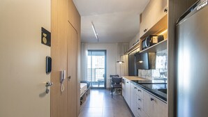 A modern hotel room with a kitchenette, a bed, a desk, and a bathroom. - Cozy Near Allianz Parque Sp-p1702b (São Paulo)