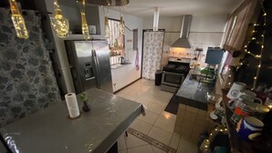A kitchen with a refrigerator, stove, and various kitchen items. - Casa Todah B&B (Liberia)