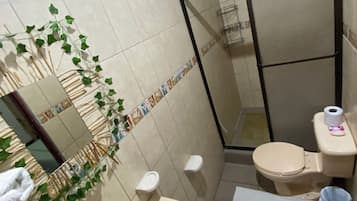 A bathroom with a sink, toilet, and shower area.