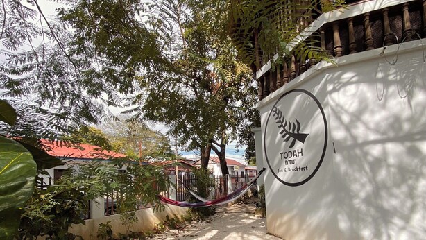 A pathway leading to a building with a sign reading "TODAHS Bed & Breakfast". - Casa Todah B&B (Liberia)