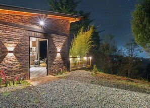 A brick building with a gravel driveway and a metal fence.