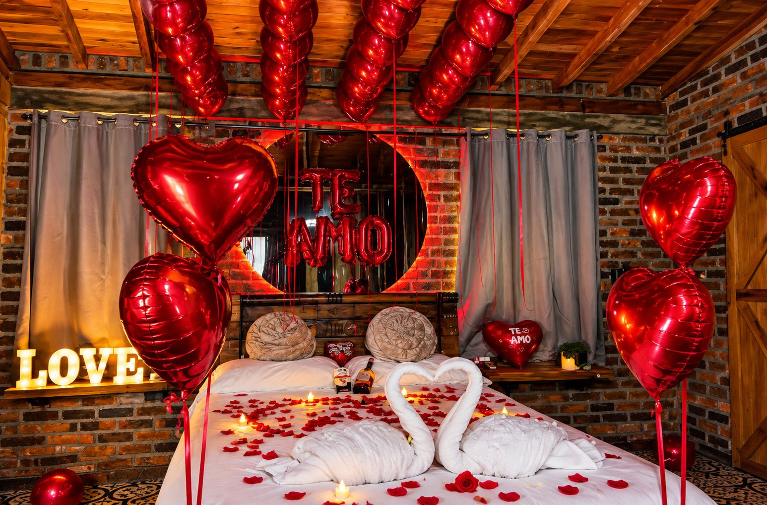 A romantic setting with a bed adorned with rose petals, swan-shaped pillows, and heart-shaped balloons.