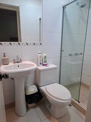 A bathroom with a white sink, toilet, and glass shower enclosure. - View of the Magic Circuit and National Stadium. Safe and quiet. 24-hour check-in (Lima)