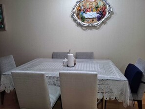 A dining room with a table set for six, featuring a lace tablecloth, white chairs, and a framed artwork above the table. - View of the Magic Circuit and National Stadium. Safe and quiet. 24-hour check-in (Lima)