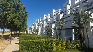 A modern building with white exteriors and multiple balconies.