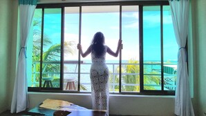 Une pièce avec une grande fenêtre, une vue sur la mer et une table avec une chaise.