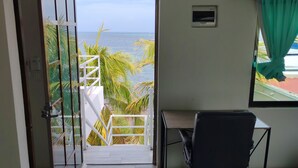 Une chambre avec vue sur la mer, un bureau et une chaise.