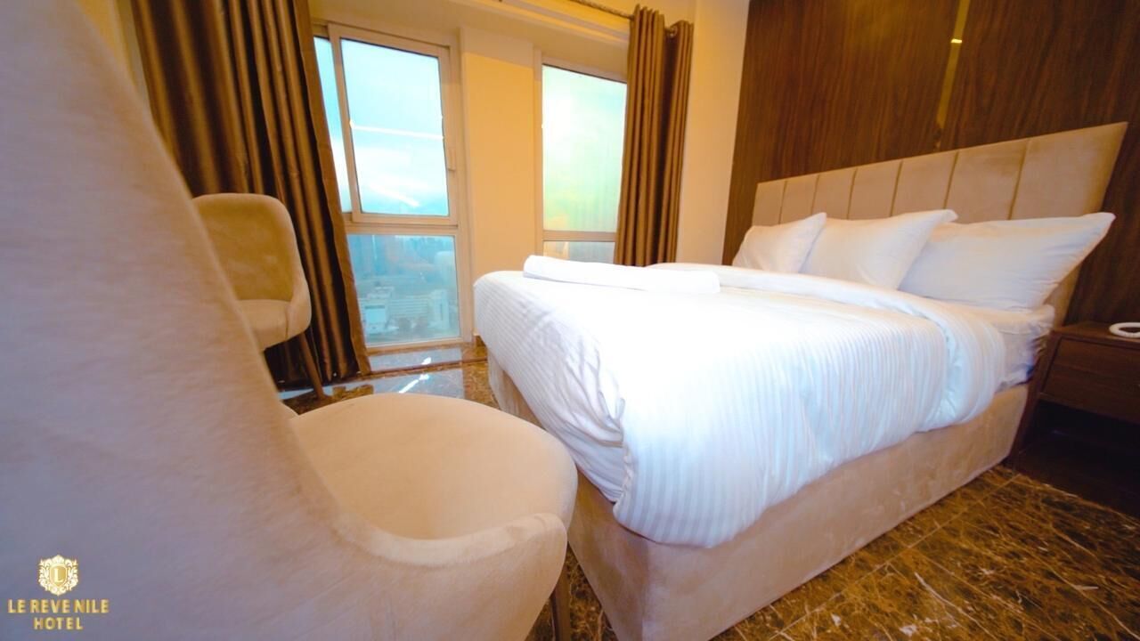 Ein Hotelzimmer mit einem großen Bett, einem Sessel und einem Nachttisch.