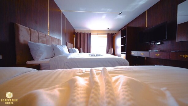 A hotel room with a large bed, a TV, and a wardrobe. - Nile View (Cairo)