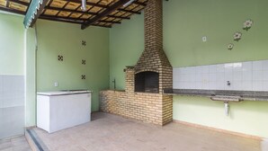 Una cocina con horno de ladrillo, refrigerador blanco y salpicadero de azulejos.