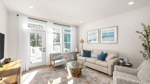 A living room with a sofa, armchairs, a coffee table, and a TV.