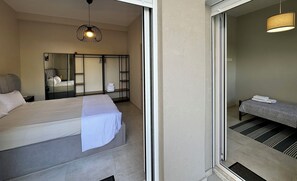 Ein Hotelzimmer mit Bett, Spiegel, Kleiderschrank und einer kleinen Sitzecke mit Handtüchern.