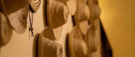 A wall with several hats hanging in a row.