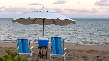 Am Strand, weißer Sandstrand, Liegestühle, Sonnenschirme