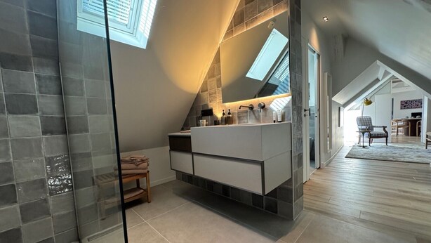 A modern bathroom with a large mirror, a built-in sink, and a glass shower enclosure. - Exceptional country apartment with pool, jacuzzi and sauna (La Chapelle-Longueville)
