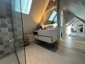 A modern bathroom with a large mirror, a built-in sink, and a glass shower enclosure. - Unique Country Home with Pool, Jacuzzi, and Sauna (La Chapelle-Longueville)