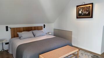 Une chambre à coucher avec un lit, une table de chevet, une lampe et un tableau au mur.