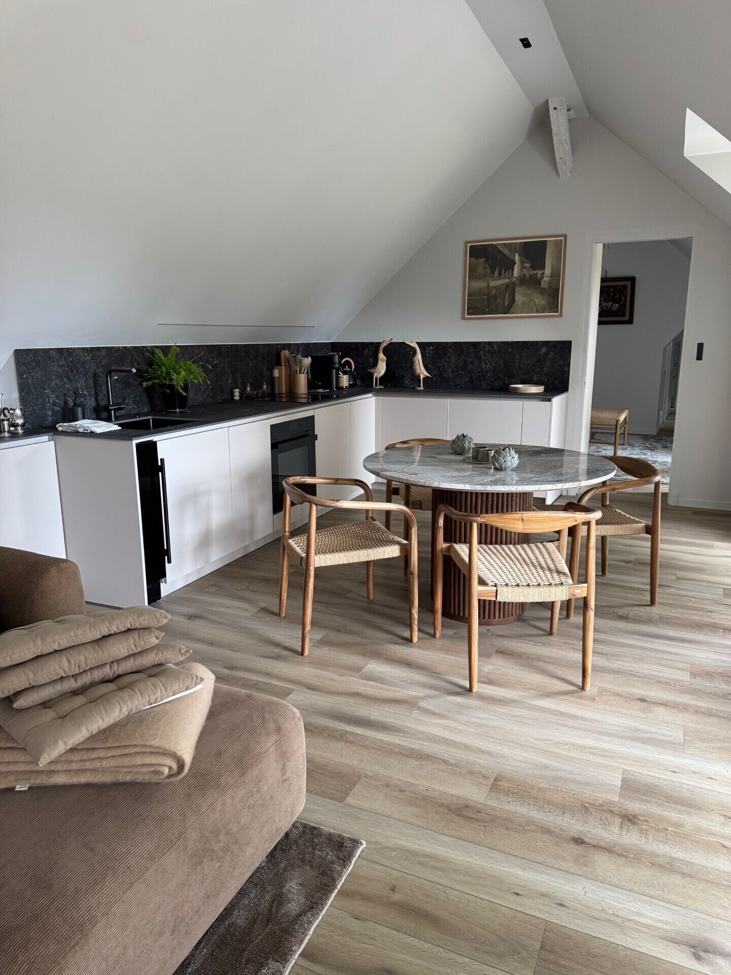 A modern loft apartment with a kitchen, dining area, and living space.