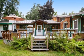 Une cabane en bois dotée d’une véranda, d’un coin repas et d’un espace extérieur abrité.