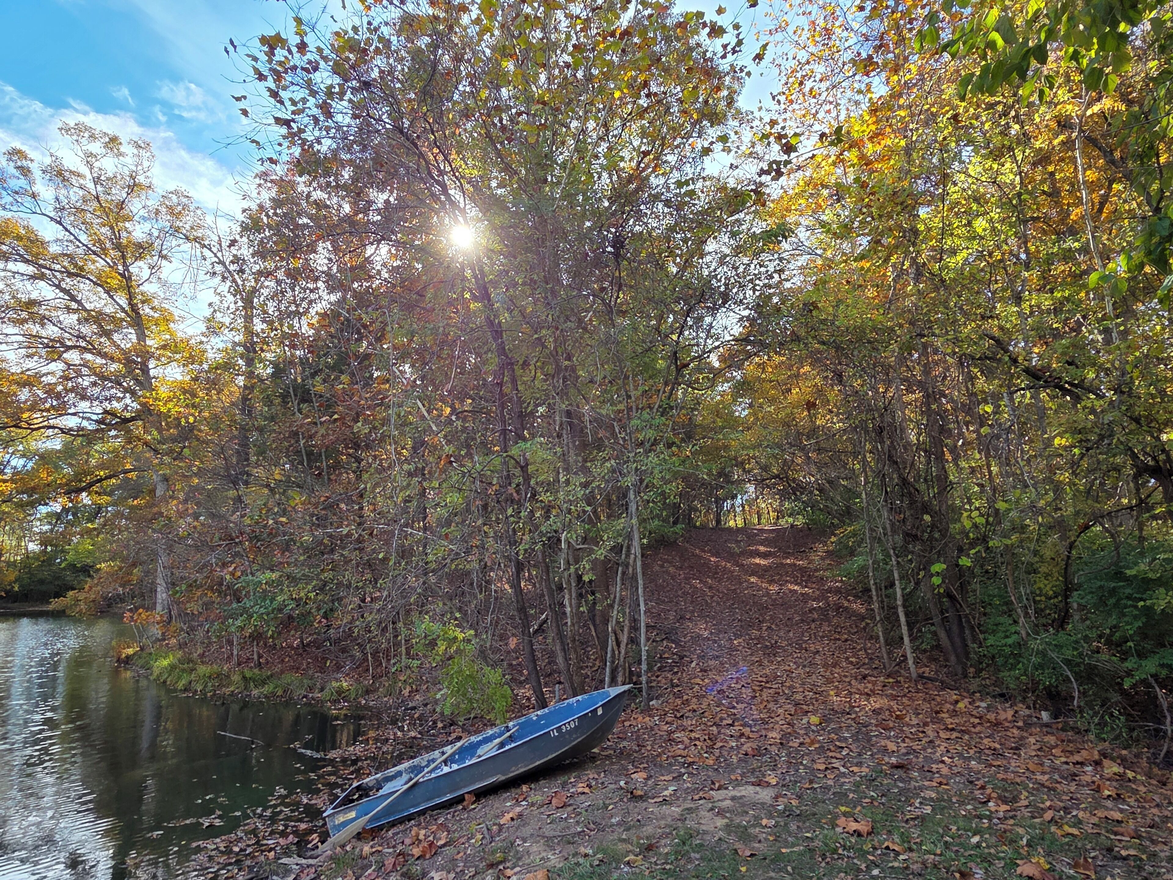A canoe on a forested path near a body of water.