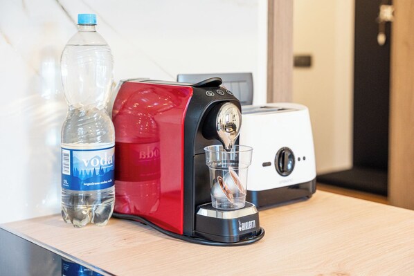 Un distributeur d’eau, une bouteille d’eau et un grille-pain, le tout posé sur une surface en bois.