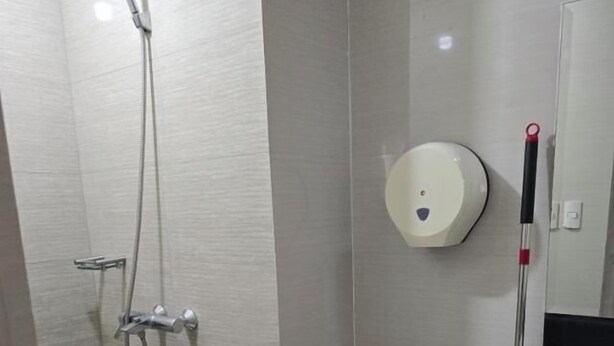A bathroom with a toilet, a bidet, a shower, and a sink. - Newport Boulevard Apartments (Pasay)