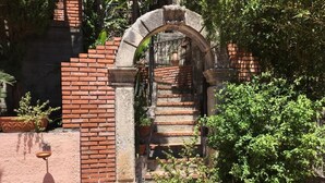 A stone archway leading to a brick staircase surrounded by greenery. - Elegant Sicilian villa in the heart of Taormina - 3 bedrooms, 3 bathrooms. (Taormina)