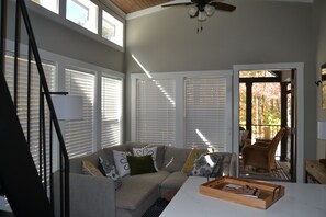 A living room with a sectional sofa, a coffee table, and a ceiling fan.