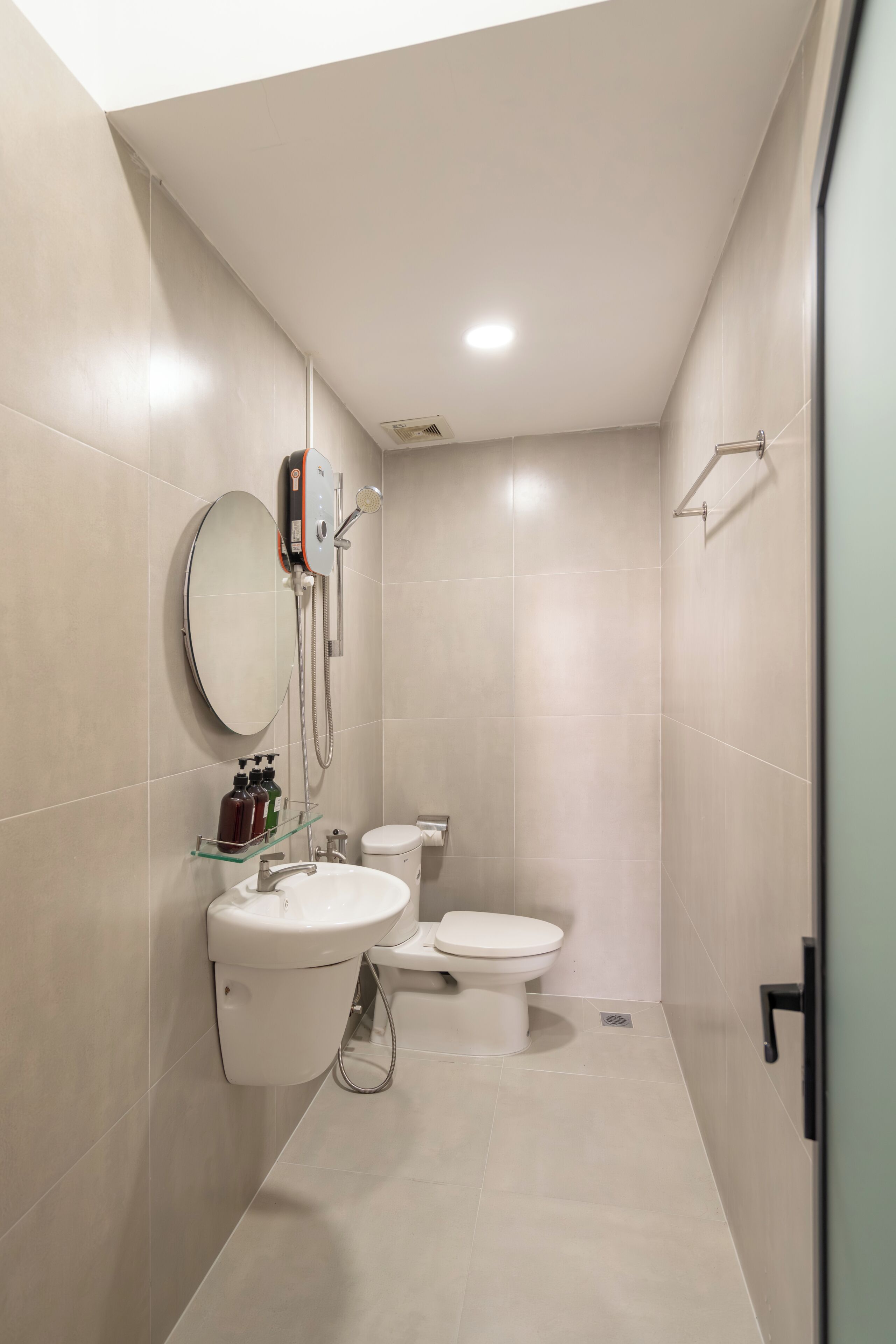 Un baño moderno con inodoro, lavamanos y ducha.